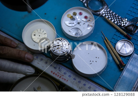 Repairing a wristwatch. Watch repair Repairing a wristwatch. Watch repair 128129088
