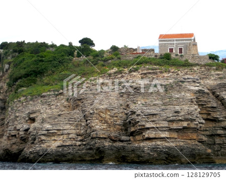 Sveti Nikola Lighthouse Perches on Rocky Cliffs Along Montenegros Serene Adriatic Coast 128129705