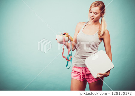 Girl with scales measuring tapes. Weight loss. Girl with scales measuring tapes. Weight loss. 128130172