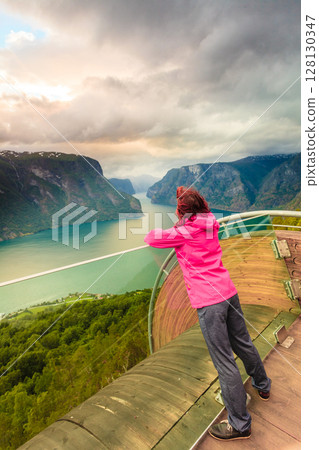 Tourist on Stegastein viewpoint, Norway 128130347