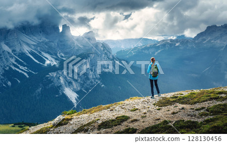 Female hiker admiring Dolomites mountain landscape in summer day Female hiker admiring Dolomites mountain landscape in summer day 128130456