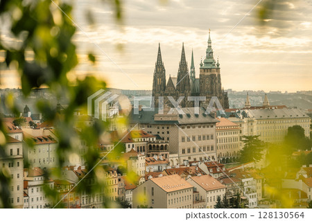 Bright morning light illuminates Prague Castle as the sun rises. The majestic spires overlook the historical buildings and rooftops of the city, creating a serene atmosphere. Bright morning light illuminates Prague Castle as the sun rises. The majestic spires overlook the historical buildings and rooftops of the city, creating a serene atmosphere. 128130564