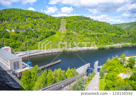 Orlik Dam and Hydroelectric Power Station are nestled in the lush landscape of Czechia, showcasing advanced renewable energy technology against a backdrop of greenery and water. 128130592