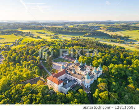 Holy Mountain in Pribram showcases a stunning Baroque complex surrounded by lush greenery, serving as a significant pilgrimage site. Visitors experience tranquility and history amidst nature. 128130595