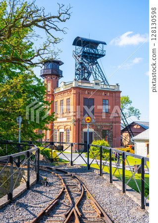 Sevcinsky mine in Brezove hory, Pribram, Czechia presents well-preserved architecture and mining equipment, highlighting the rich mining history of the region under a clear blue sky. 128130598