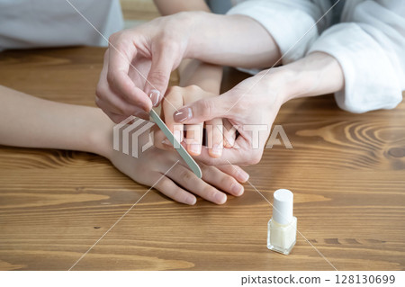 Mother files her daughter's nails Mother files her daughter's nails 128130699