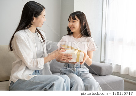 Mother giving presents to her daughter 128130717