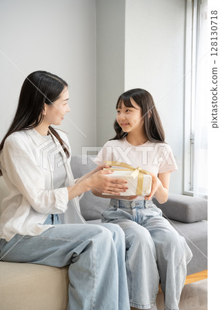 Mother giving presents to her daughter 128130718