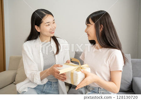 Mother giving presents to her daughter 128130720