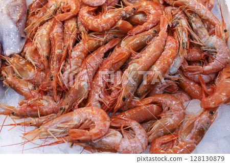 Vibrant seafood at Greek fish market features fresh shrimp piled on ice, illustrating local fishing culture and daily trade of marine delicacies. Vibrant seafood at Greek fish market features fresh shrimp piled on ice, illustrating local fishing culture and daily trade of marine delicacies. 128130879