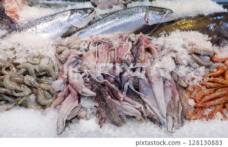 Colorful display of fresh seafood at fish market in Greece. Customers can find various fishes and marine delicacies on ice, ready for purchase and enjoyment. Colorful display of fresh seafood at fish market in Greece. Customers can find various fishes and marine delicacies on ice, ready for purchase and enjoyment. 128130883
