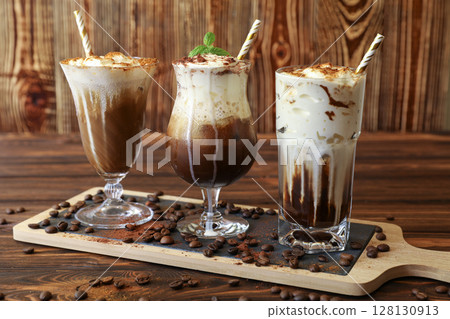 Three delicious coffee beverages are displayed on wooden board, showcasing rich colors and creamy textures. Each drink features unique toppings and presentation. 128130913