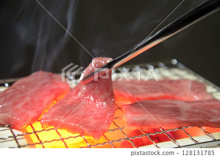 Grilling beef on a charcoal grill with rising smoke Grilling beef on a charcoal grill with rising smoke 128131785