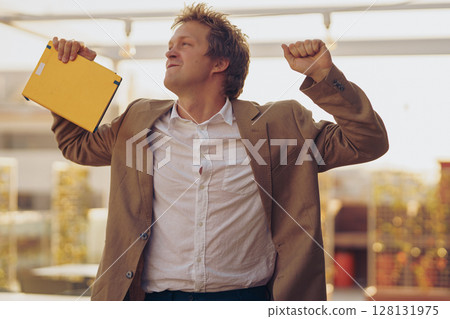 A Joyful Businessman Celebrating His Success in a Modern and Stylish Office Space A Joyful Businessman Celebrating His Success in a Modern and Stylish Office Space 128131975