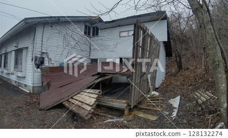 Destroyed exterior wall caused by collapsed shed 128132274