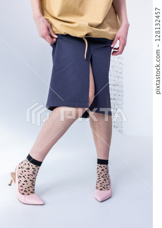 Elegant woman in beige windbreaker jacket and black skirt on white background. Fashionable female style. Studio photography. Vertical photo. High quality photo 128132457