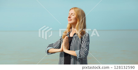 Calm relaxing healthy young woman meditates, happy girl practicing yoga on the beach on sea Calm relaxing healthy young woman meditates, happy girl practicing yoga on the beach on sea 128132590