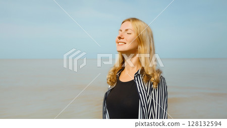 Calm relaxing young woman meditates, happy girl practicing breathing exercises on beach on sea Calm relaxing young woman meditates, happy girl practicing breathing exercises on beach on sea 128132594