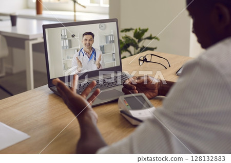 Man with hypertension having medical consultation with online doctor on laptop computer 128132883