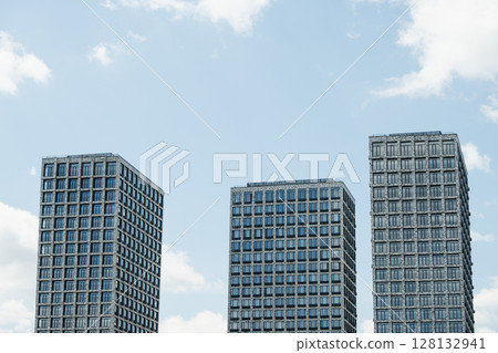 Three new buildings with modern apartments at city. Architecture skyscrapers against blue cloudy sky. Three new buildings with modern apartments at city. Architecture skyscrapers against blue cloudy sky. 128132941