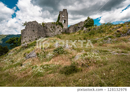 Ruins Of Grad Vipava In Slovenia: Ancient Stone Walls Covered In Ivy Standing On A Grassy Hilltop Under A Dramatic Cloud-Filled Sky In The Scenic Vipava Valley Ruins Of Grad Vipava In Slovenia: Ancient Stone Walls Covered In Ivy Standing On A Grassy Hilltop Under A Dramatic Cloud-Filled Sky In The Scenic Vipava Valley 128132976