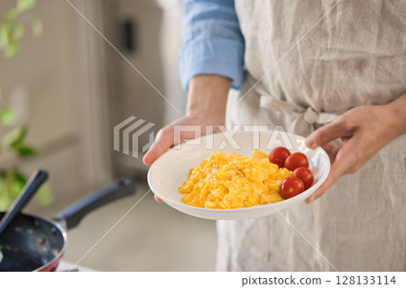 Hands of a young man preparing egg dishes 128133114