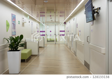 Modern hospital corridor with changing tables, waiting area, and closed doors leading to examination rooms, emphasizing hygiene and child-friendly design. Modern hospital corridor with changing tables, waiting area, and closed doors leading to examination rooms, emphasizing hygiene and child-friendly design. 128133138