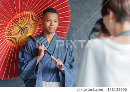 A photographer taking pictures of foreign tourists wearing yukata 128133806