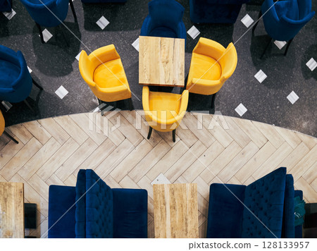 Restaurant with a checkered floor and blue and yellow chairs 128133957