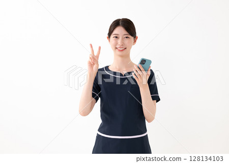 Beautician with a smartphone Beautician with a smartphone 128134103