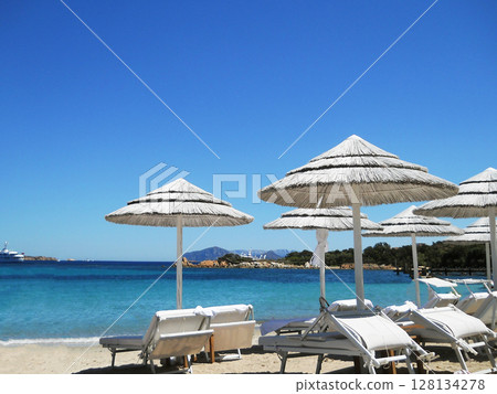 Escape to the stunning shores of Sardinia with these vibrant stock photos capturing the essence of Mediterranean tranquility. Featuring a pristine beach lined with straw umbrellas, sun loungers, and Escape to the stunning shores of Sardinia with these vibrant stock photos capturing the essence of Mediterranean tranquility. Featuring a pristine beach lined with straw umbrellas, sun loungers, and 128134278