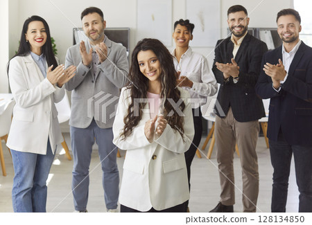 Happy diverse group of colleagues clapping, celebrating achievement, woman leader applauses 128134850