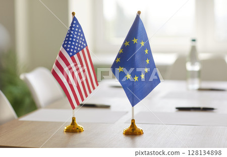 Flags of United States and European Union on table prepared for diplomatic negotiation or summit. 128134898