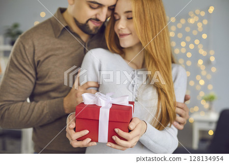 Happy young couple celebrating their special day and enjoying romantic presents Happy young couple celebrating their special day and enjoying romantic presents 128134954