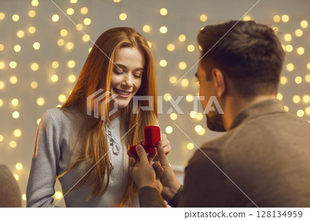 Man with a ring in his hands asks a woman will you make me the happiest man and marry me. Man with a ring in his hands asks a woman will you make me the happiest man and marry me. 128134959