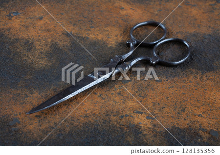 Vintage embroidery scissors on rusty background 128135356