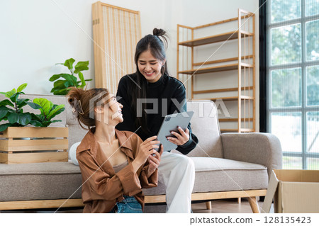 Happy Lesbian Couple Moving into Smart Home, Unpacking Boxes and Using Tablet to Set Up Modern Technology in New House Happy Lesbian Couple Moving into Smart Home, Unpacking Boxes and Using Tablet to Set Up Modern Technology in New House 128135423