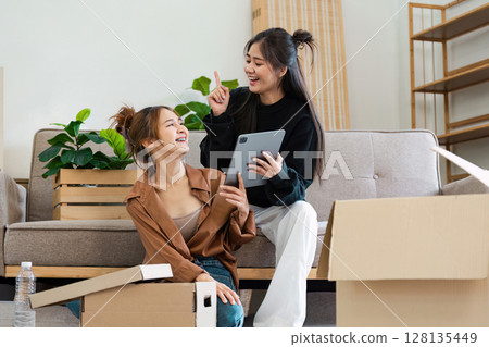 Happy Lesbian Couple Moving into Smart Home, Unpacking Boxes and Using Tablet to Set Up Modern Technology in New House Happy Lesbian Couple Moving into Smart Home, Unpacking Boxes and Using Tablet to Set Up Modern Technology in New House 128135449