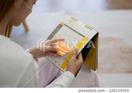 Woman Holding Birth Control Pills and Calendar, Planning Pregnancy, Family Planning Concept 128135450