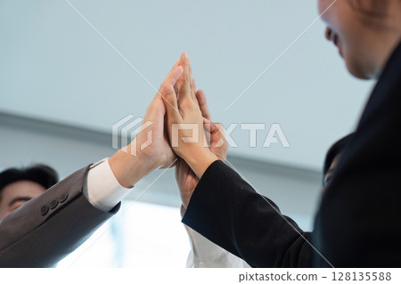 Professional Business Meeting with Team Collaboration and High-Five Gesture in Modern Office Setting 128135588