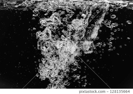 許多氣泡在黑色背景下飛入水中。 128135664