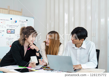 Creative Team collaboration on UX UI Design Project in Modern Office Setting with Whiteboard and Digital Devices 128135772