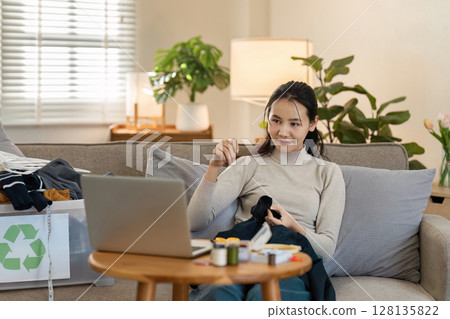 Woman Engaged in Sustainable Living by Recycling Clothes at Home, Promoting Eco-Friendly Practices and Environmental Conservation 128135822