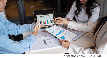 Business Collaboration Meeting with Data Analysis and Yearly Report Discussion in Modern Office Setting 128135838