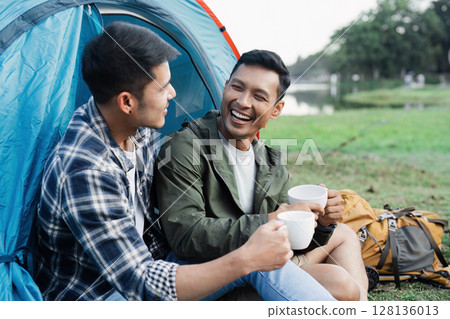 Happy Couple gay lgbt Campers Enjoying Morning Coffee in Front of Tent by Scenic Lakeside - Travel Camping Adventure in Nature with boyfriends Happy Couple gay lgbt Campers Enjoying Morning Coffee in Front of Tent by Scenic Lakeside - Travel Camping Adventure in Nature with boyfriends 128136013