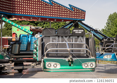 a "Sizzler ride" a ride with multiple arms extending from a central point, each arm holding several cars or seats. 128136051