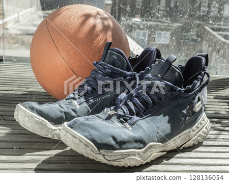Basketball shoes and basketball ball are placed on the balcony. Basketball shoes and basketball ball are placed on the balcony. 128136054