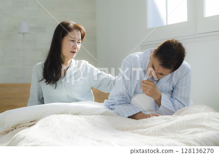 Senior couple in poor health waking up 128136270