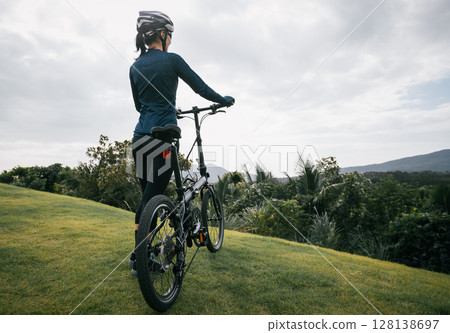 Riding folding bike to tropical mountain peak Riding folding bike to tropical mountain peak 128138697