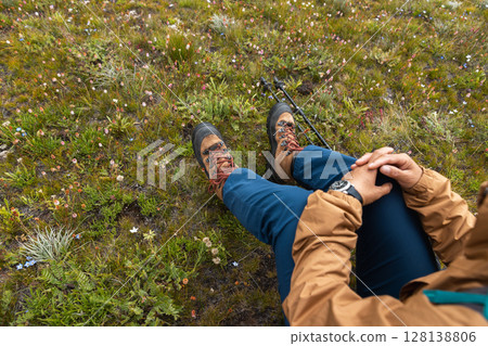 Woman backpacking on high altitude mountains top,sit on the grass 128138806